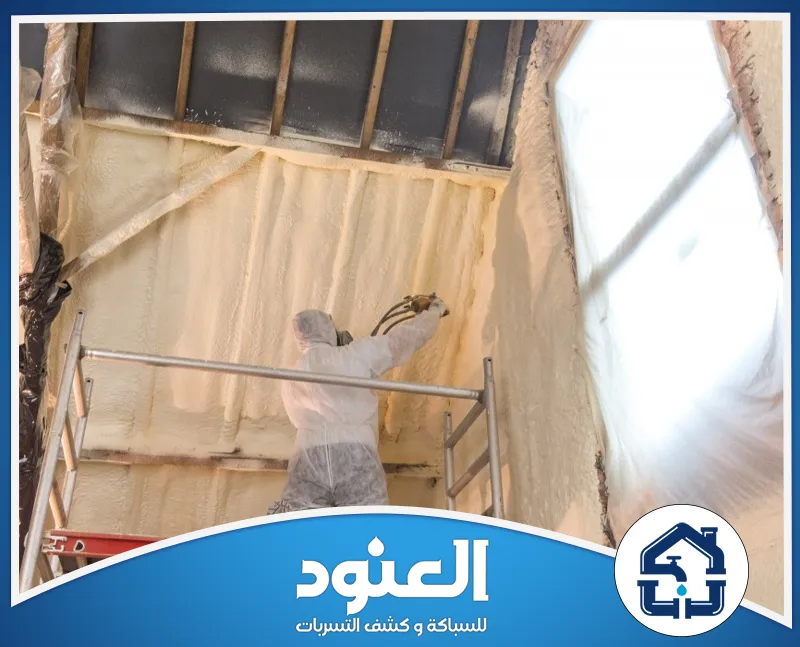 شركة عزل فوم ببقعاء 0534999675 شركة العنود عامل يرتدي ملابس واقية ويرش عازل الفوم على الجدران والأسقف لتحسين العزل.