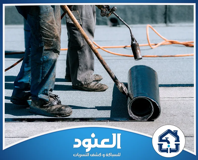شركة عزل اسطح خرسانية 0500805875 شركة العنود عمال يطبقون لفائف العزل المائي على سطح مبنى باستخدام أدوات التسخين.