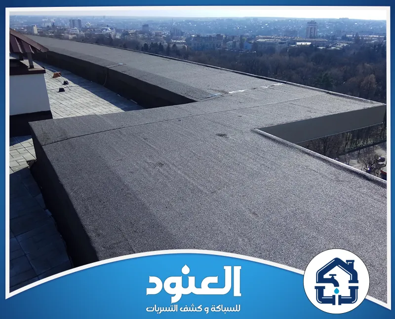 شركة عزل اسطح المنازل حوطة سدير 0500805875 شركة العنود سطح مبنى واسع مغطى بطبقة عزل مائي، مع إطلالة بانورامية على المدينة.